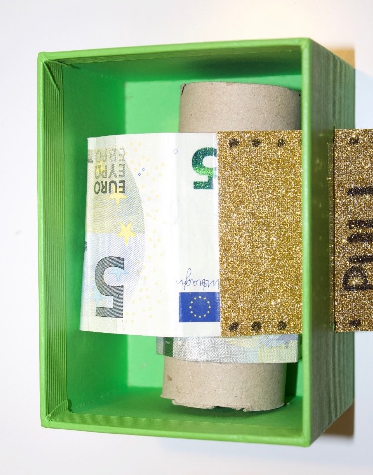 Rolle einlegen und Geld durch Schlitz schieben.